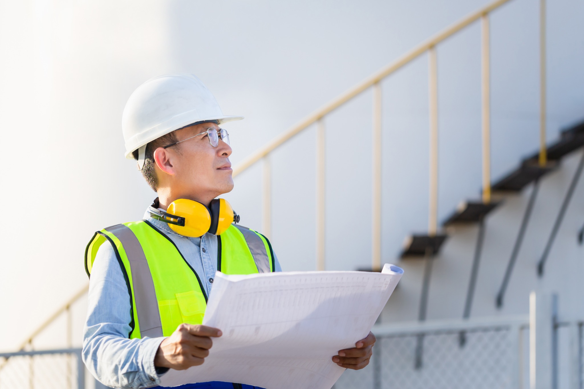 Engineer reviewing a tank and technical drawings